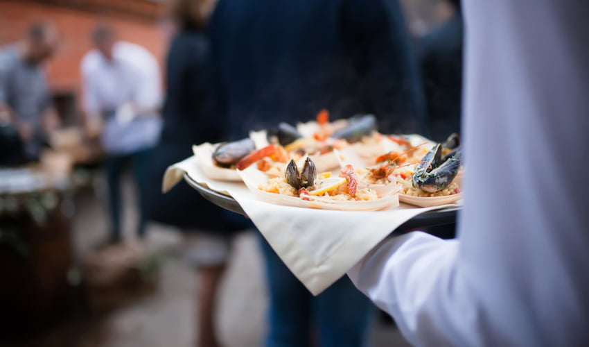 seafood paella being carried by a waiter