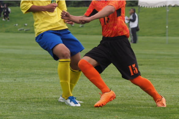 soccer players kicking a ball