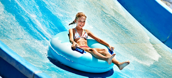 a child in an inner tube rides a water slide at Adventure Park in Tampa